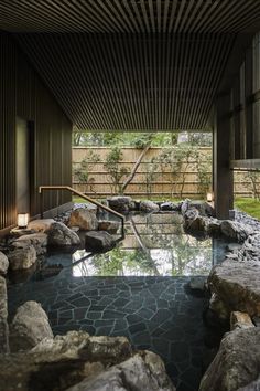 an indoor swimming pool surrounded by rocks and trees