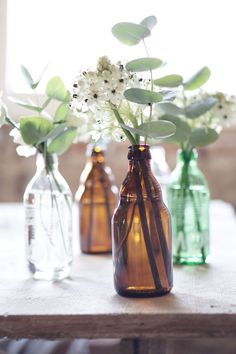 three vases with flowers in them sitting on a table