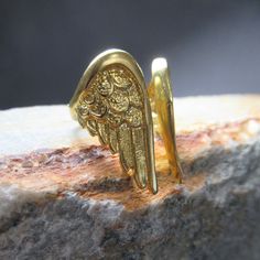 Striking Golden Angel Wing Ring With An Adjustable Band. This Design Is So Unusual, And Comfortable To Wear! The Golden Angel Wing Design Measures Approximately 27mm From Top To Bottom, And At The Smallest Ring Size, The Wings Measure 34mm Across. That Translates To Just Over 1 Inch Tall Along The Length Of Your Finger, With An Adjustable Band Size. **Our Fine Jewelry Is Always Boxed For Shipping.** Please Take Your Time With The Photos And Consider Them Part Of The Description. Let Me Know If Y Angel Wings Ring, Angel Wing Design, Wing Ring, Golden Angel, Angel Wing Ring, Angel Wings Design, Angel Wings Jewelry, Wing Design, Gold Angel Wings