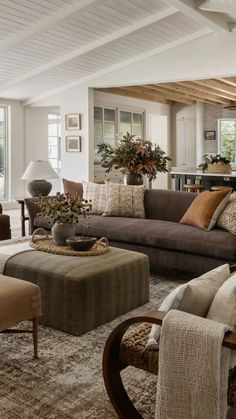 a living room filled with lots of furniture and decor on top of carpeted flooring