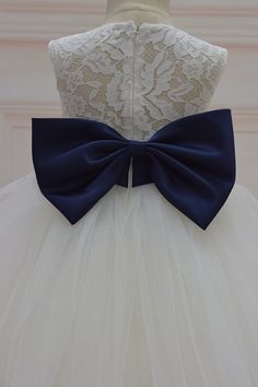 a white dress with a blue bow on it