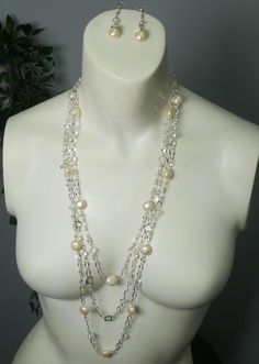 An abstract silver chain is strung to clear beads and brushed cream pearls to form this lovely set. Featuring unique diamond silver chain details and clear gems that are plated around the crystal! These two pieces are magnificent and are sure to stand out! Handmade and supports future art! Multi-strand Pearl Drop Necklaces For Party, Elegant Dangle Pearl Necklace For Parties, Elegant Pearl Dangle Necklace For Party, Elegant Pearl Pendant Necklace For Parties, Silver Crystal Pearl Necklace As A Gift, Silver Crystal Pearl Necklace Gift, Silver Pearl Necklace With Beaded Chain, Silver Crystal Pearl Necklace For Gift, Party Silver Jewelry With Pearl Chain