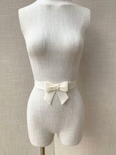 This super elegant delicate bridal belt is beautifully hand made out of silk organza. It features center bow detail with the hanging tails. The belt is finished in the back with the hidden clasp. Available in white, off white or ivory, please see the last photo for the color reference. This belt measures 1 1/4" wide and the length is finished to your measurements. Shown in the photos in ivory. We can make this belt in any other color if needed, please inquire about the custom order. * Please inc Elegant Organza Bridal Accessories For Ceremony, Elegant Bridal Accessories With Satin Bow, Elegant Wedding Corset Belt, Elegant White Bow With Ribbon, Elegant White Ribbon Bow, Elegant Cream Bow For Parties, Elegant Cream Bow For Party, Elegant Adjustable Sashes For Formal Occasions, Elegant Adjustable Sash For Formal Occasions