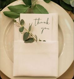 a white plate topped with a folded thank you card next to a green leafy plant