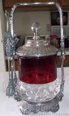 an ornate silver and red glass container