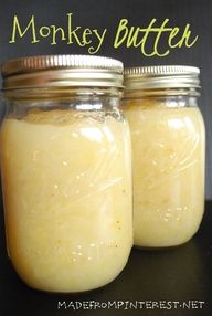 two jars filled with yellow liquid sitting on top of a black table next to each other