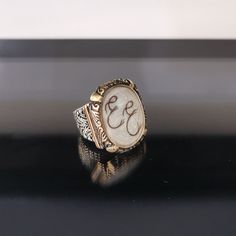 "✓ Personalized Hair Locket Initial Ring For Men. Our Solid 925 Sterling Silver ring with; %100 hand crafted, gold workmanship is specially produced for you, Jewelry made with love for your special occasions. ---● R I N G ∙ D E T A I L S ●--- * The Case Of The Ring is SOLID 925 STERLING SILVER. * The upper part of the ring is made of UV stable resin. And your hair will be safe in it. * We create letters/designs by hand crafted by separating your hair into strands. * The shapes of the letters/des Wedding Initial Ring In White Sterling Silver, Handmade White Sterling Silver Signet Ring, Handmade White Signet Ring In Sterling Silver, Handmade Adjustable Antique Engraved Ring, Heirloom Engraved Ring Jewelry, Elegant White Initial Ring With Engraving, Handmade Antique Adjustable Engraved Ring, Antique Handmade Adjustable Engraved Ring, Elegant White Initial Ring Engraved