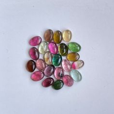 several different colored stones on a white surface