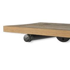 a wooden shelf with two black wheels on it