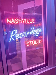 a neon sign in the window of a recording studio