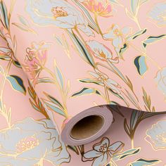 a roll of pink and blue floral wallpaper with gold foiling on the edges