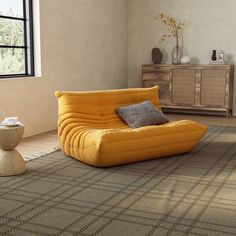 a yellow chair sitting on top of a rug in a living room