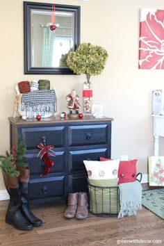 a blue dresser sitting next to a christmas tree and other decorations on top of it