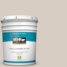 the behr paint and primer in one is shown on a brown background with white trim