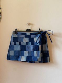 a blue skirt hanging on a wall with a clock in the backgroung