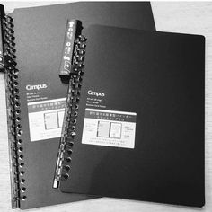 two black notebooks sitting next to each other