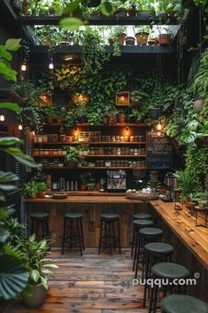 an indoor bar with lots of plants growing on the wall and wooden tables in front of it