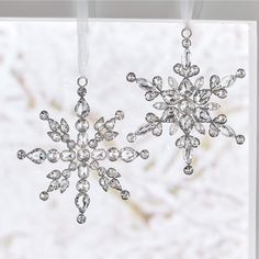 two crystal snowflakes hanging from a window