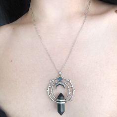 Thorns tell the beholder to love a beauty but from a safe distance. For if they come to pluck her beauty she will scratch back. Our magical circle of thorns hold a protective obsidian stone with a floating crescent moon above it under a labradorite stone. Labradorites enhance intuition. Our chain is 18" long with a 3" extension for additional length. Recycled brass base with a darker silver finish. Stones are genuine gemstone. All orders over $50 ship for free within the USA. All orders usually Black Crescent Jewelry For Festival, Black Moon Phase Necklaces For Festival, Black Moon Phase Necklace For Festival, Witchy Metal Jewelry With Moon Charm, Mystical Round Pendant Metal Jewelry, Gothic Crescent Moon Charm Jewelry, Mystical Metal Round Pendant Jewelry, Gothic Festival Jewelry With Moon Charm, Black Crescent Metal Jewelry