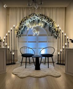 two chairs sitting at a table in front of a lighted sign that says happy birthday