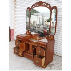 an antique wooden vanity with mirror and drawers