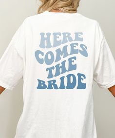 A "Here Comes The Bride" statement shirt is a special gift for an engagement, wedding or bachelorette party. ♥ PRODUCTION: After receipt of order and preview release, 1-5 days (average 2-3 days) ♥ DELIVERY TIME: 2-5 days (Average 3 days) ♥ MATERIAL: material: 100% cotton Grammage: 142 g/m² (unisex) Sizes: S to 2XL Fit: Unisex ♥ CARE: Machine wash: max. 30 degrees Dryer: low temperature Ironing: Steam or Dry, medium temperature no dry washing ♥ DTG PRINTING PROCESS: Digital printing (DTG: Direct Bride Shirt, Gift For Bride, Bride Shirts, Bridal Gift, Statement Shirt, Dtg Printing, Here Comes The Bride, Bride Bridal, Here Comes