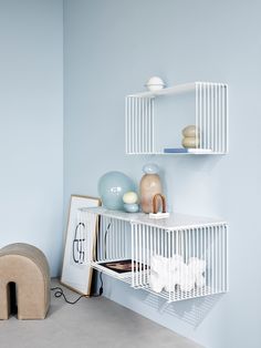 a white shelf with some vases on top of it and a dog bed in the corner