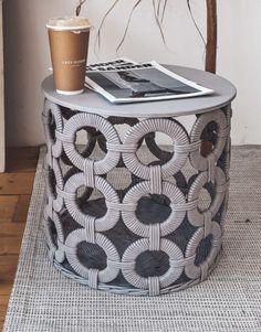 a coffee cup sitting on top of a table next to a magazine and a book