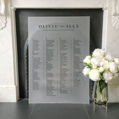 a vase filled with white flowers sitting next to a sign that says opera and alex