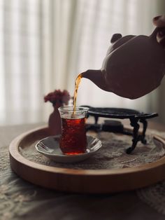 tea being poured into a cup on a tray