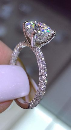 a close up of a person holding a diamond ring