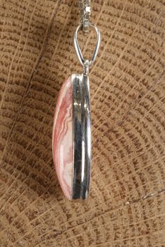 Rhodochrosite Marquise Pendant Approx. Dimensions: 30x15x8 mm This pendant is made with .925 Sterling Silver. Chain is not included. Rhodochrosite is a manganese carbonate mineral recognized for its distinctive pink to rose-red color. It is commonly found in various locations worldwide, including Argentina, Peru, South Africa, and the United States. Historically, rhodochrosite has been known since ancient times and has been utilized as an ornamental stone in jewelry and carvings. Its name is der Pink Agate Pendant Jewelry, Pink Opal Jewelry With Natural Stones For Gifts, Unique Pink Jewelry With Large Pendant, Silver Rhodonite Jewelry With Natural Stones, Silver Jewelry With Natural Stones And Rhodonite, Pink Agate Pendant Necklace, Rhodonite Gemstone Jewelry For Gift, Pink Sterling Silver Jewelry With Large Pendant, Pink Opal Pendant Jewelry