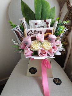 a bouquet of flowers sitting on top of a white chair next to a card box