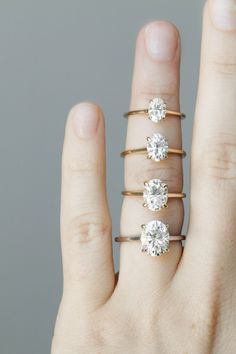 a woman's hand with three rings on it and four diamonds in the middle