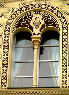 an ornately decorated window with gold trim and decorative windowsills on the side of a building