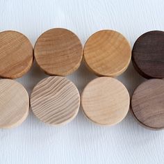 six wooden discs lined up on top of each other, all in different colors and sizes