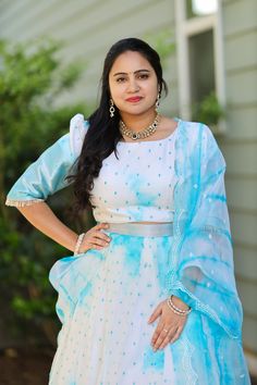 Dreamy Organza half saree! The blend of light blue and white is simply mesmerizing. ✨ 👗 Outfit Details: * Blouse: White with delicate blue motifs, featuring stylish puffed sleeves. * Skirt: White with light blue border, adorned with matching blue motifs. * Dupatta: Sheer organza with light blue tie-dye patterns and scalloped edges. Size: 38-40 Length of lehanga: 41 inches premium fabrics. Alterations extra. White Unstitched Organza Blouse Piece, White Blouse For Eid Party, Blue Unstitched Organza Choli, Blue Organza Blouse Piece With Dupatta, Blue Organza Choli For Eid, Light Blue Organza Dupatta For Festive Occasions, Summer Organza Lehenga With Dupatta, Traditional Light Blue Organza Dress, White Sharara For Summer Party