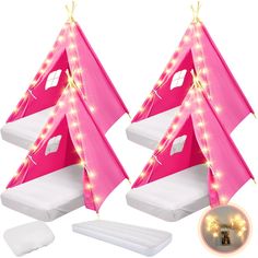 two pink tents with lights on them are next to pillows and pillow protectors for sleeping