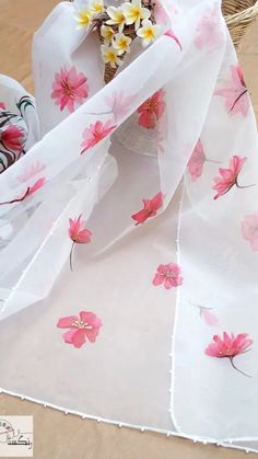 the table is covered with pink flowers and white fabric, along with chocolate candies