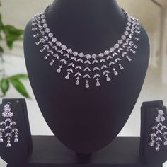 Indulge in the understated beauty of our 'Silver Lining' Western Necklace Set. The dazzling white stones lend a touch of brilliance, adding a hint of glamour to your look. Whether paired with casual attire or formal wear, this versatile set is sure to become a cherished addition to your jewelry collection, effortlessly enhancing your elegance. Our CZ Jewelry Sets are the most difficult ones to make. It takes over 80 hours of Design work to design each of these handcrafted Masterpieces. Handcraft Glamorous Silver Necklaces For Celebrations, Glamorous Silver Necklace For Celebration, Silver Necklaces With Sparkling American Diamonds, Classic Silver Jewelry Sets With Brilliant Cut, White Gold Necklaces With Sparkling Stones For Celebration, Diamond White Rhinestone Necklace, Dazzling Silver Diamond Jewelry Sets, Formal White Jewelry Sets With Sparkling Stones, Dazzling White Gold Bridal Necklace With Sparkling Stones