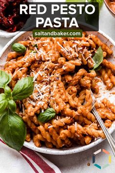 red pesto pasta in a white bowl with basil on top