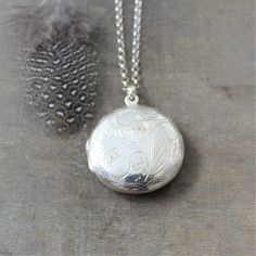 "This vintage sterling silver locket is engraved with a classic swirl design on the front and back. The large round locket opens to revealing two compartments awaiting your favorite photos. The pendant is suspended from a new sterling silver chain adorned with tiny amethyst stones at the clasp. Locket 30 mm Necklace 24\" (61cm) ✦All of our lockets ship with complimentary insurance✦ ✤Our entire selection of lockets can be found here✤ http://www.etsy.com/shop/LexiandGem?section_id=7506972" Elegant Pendant Necklaces With Engraving Option, Classic Oval Pendant Jewelry With Engraving Option, Wedding Pendant Jewelry With Engraving Option, Classic Wedding Necklaces With Engraving Option, Classic Wedding Necklace With Engraving Option, Engraved Locket Necklace With Round Pendant, Classic White Gold Locket Necklaces, Silver Heirloom Oval Necklace, Vintage White Gold Jewelry With Engraving Option