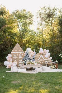 an outdoor party with balloons and gingerbread houses