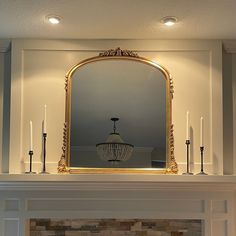 a fireplace with candles and a mirror above it