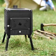 a black stove sitting on top of a grass covered field