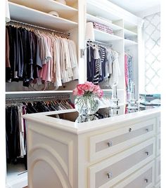 an organized closet with clothes and flowers