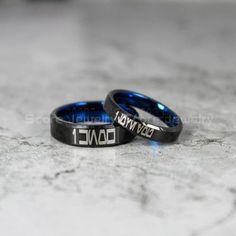 two rings with the words her king and her queen engraved on them sitting on a marble surface