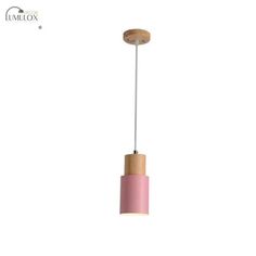 a pink and wooden light hanging from a ceiling