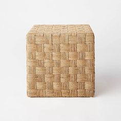 a square woven stool made out of straw