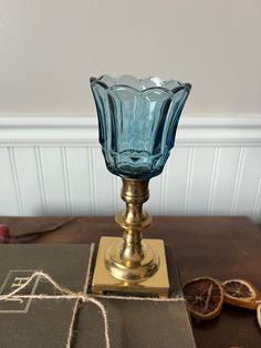 a blue glass vase sitting on top of a wooden table